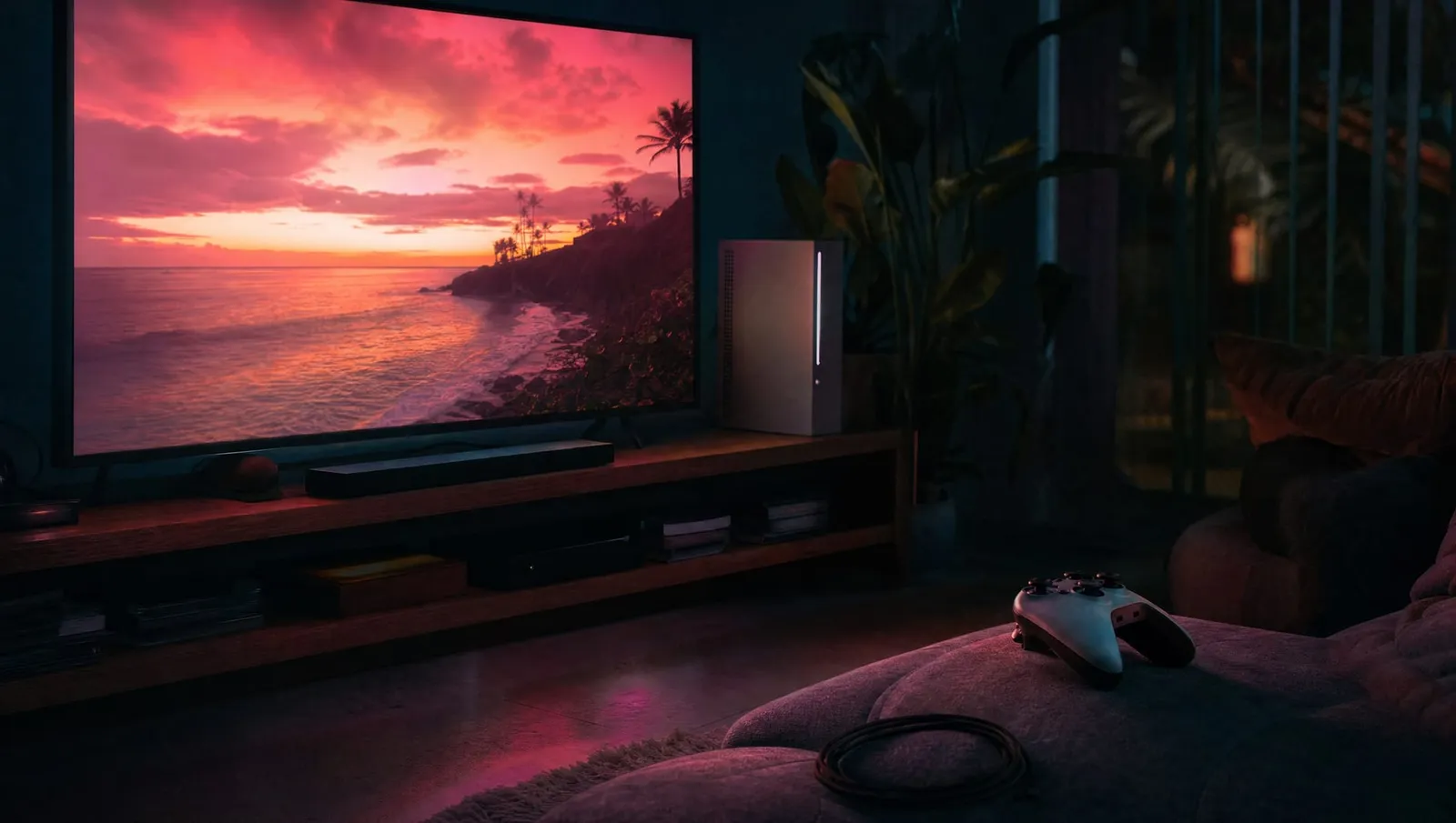 A dark living room lit by a television, a games console on the shelf and a controller on the couch